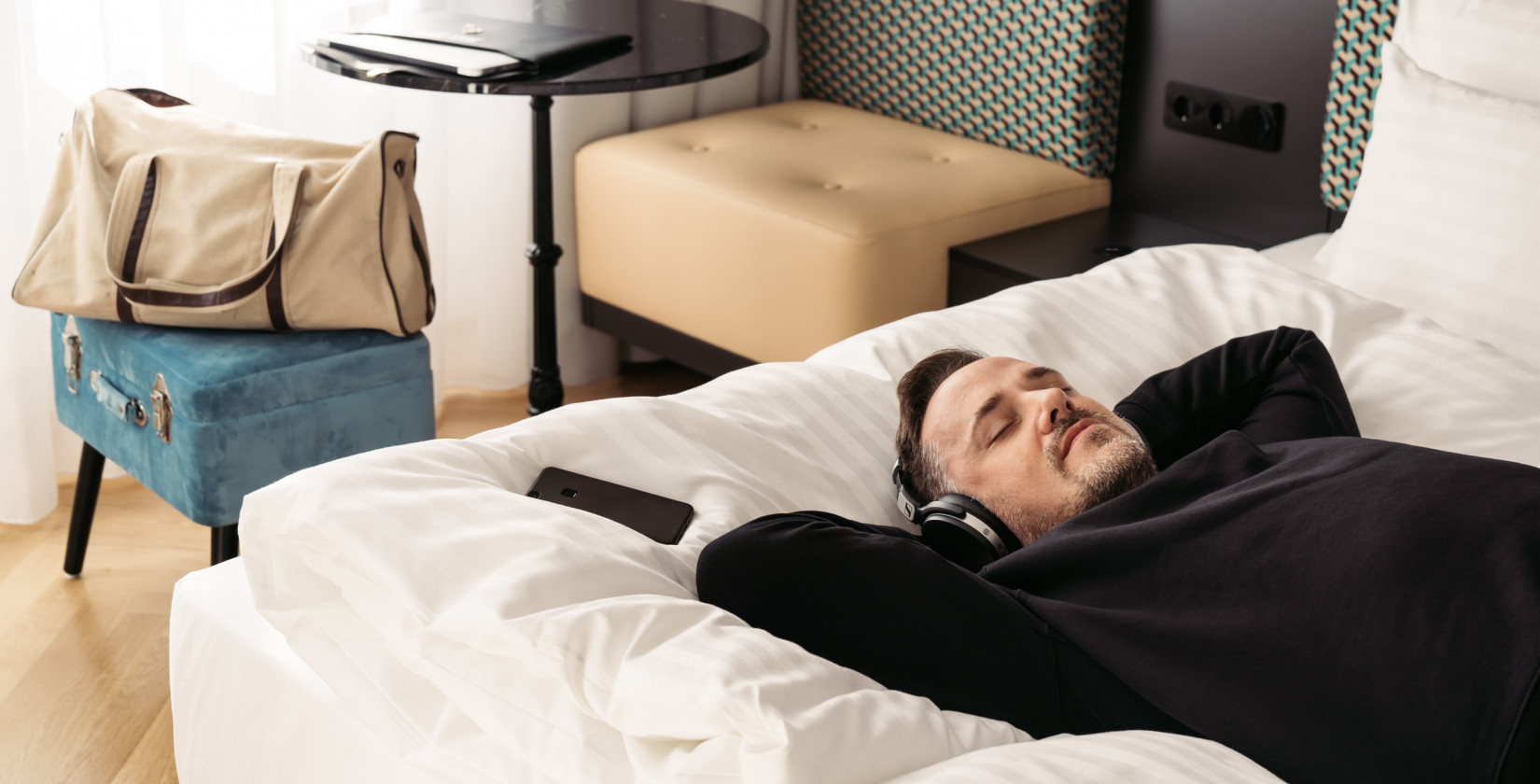 Man relaxing in his hotel room at the Boutique Hotel Schani Salon in the centre of Vienna