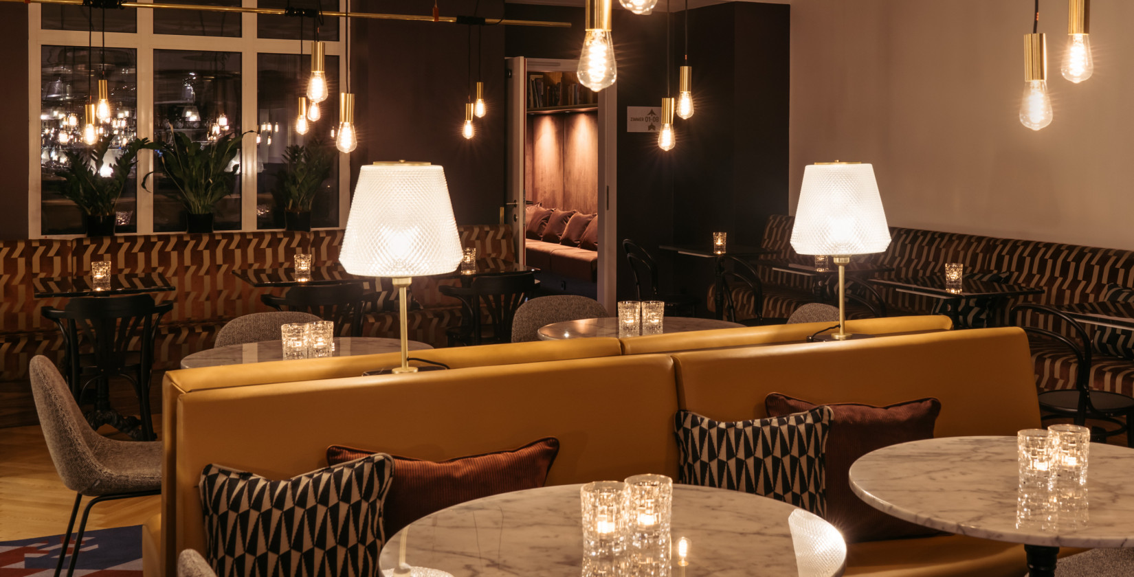 Illuminated interior of the lobby and bar at Hotel Schani Salon