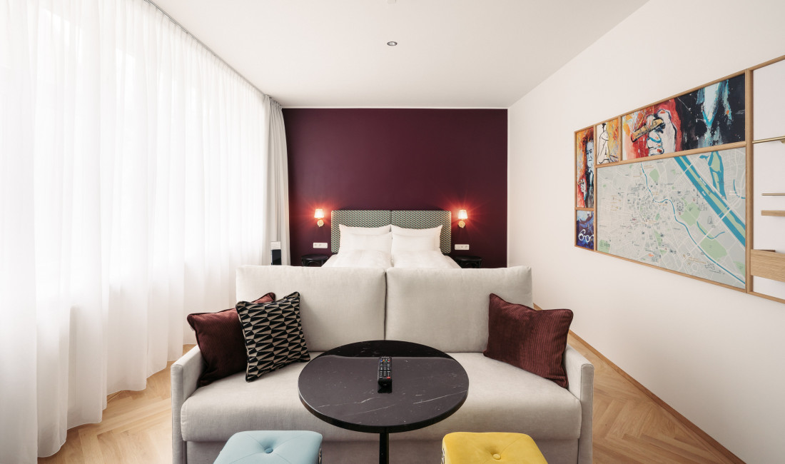 Couch and bed in Smart Atelier room in Hotel Schani Salon