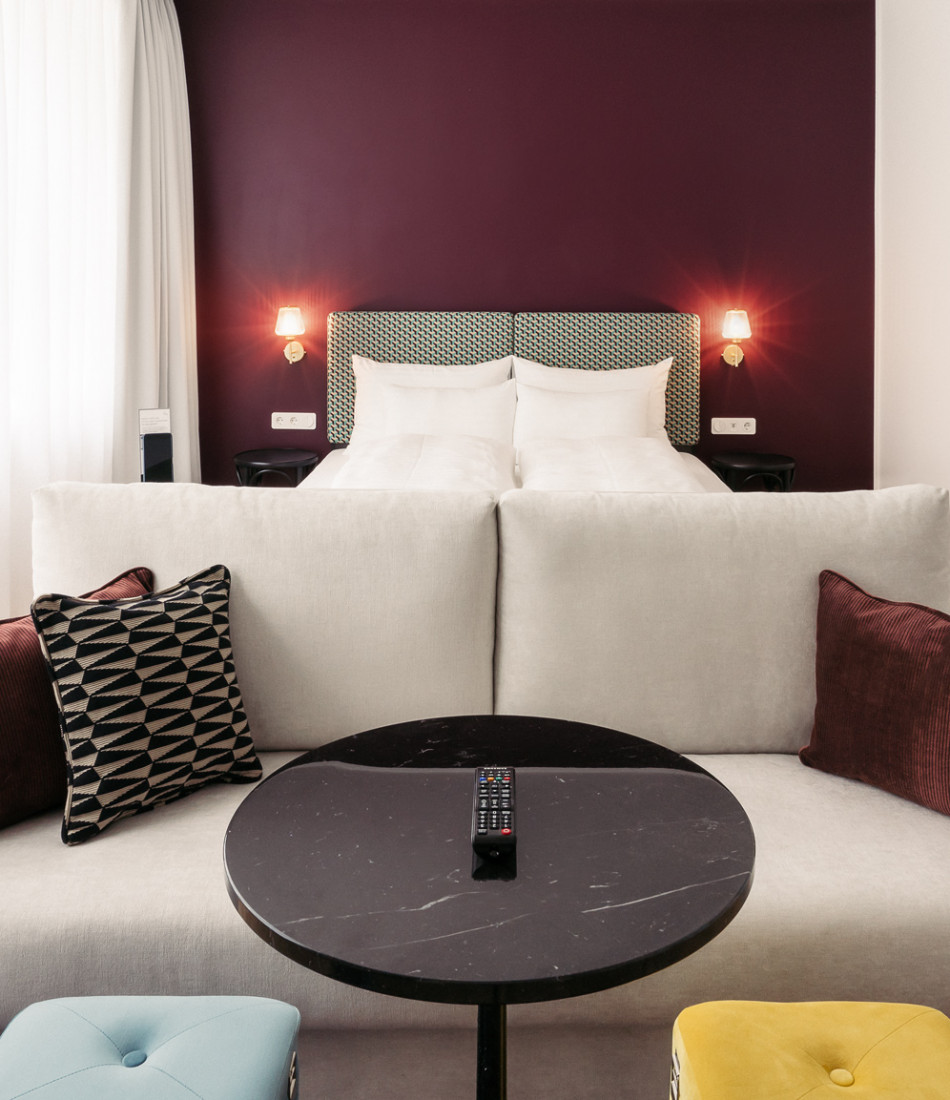 Couch und Bett im Smart Maisonette Zimmer im Hotel Schani Salon