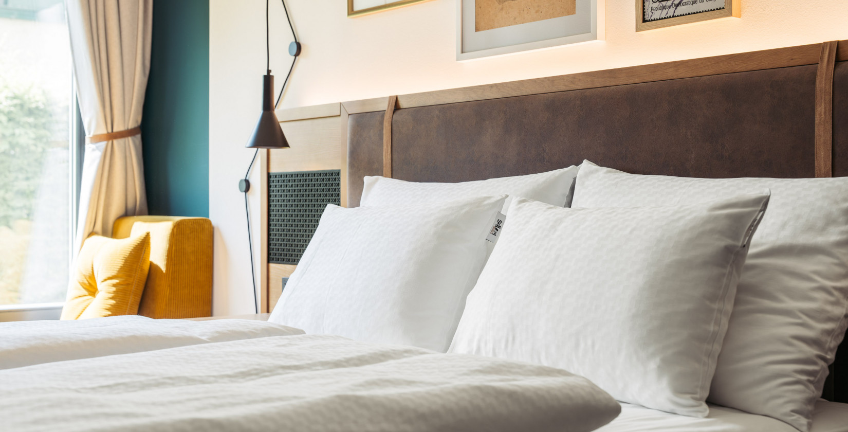 Komfortables Bett mit weißen Bezügen im Hotel Schani UNO City Wien