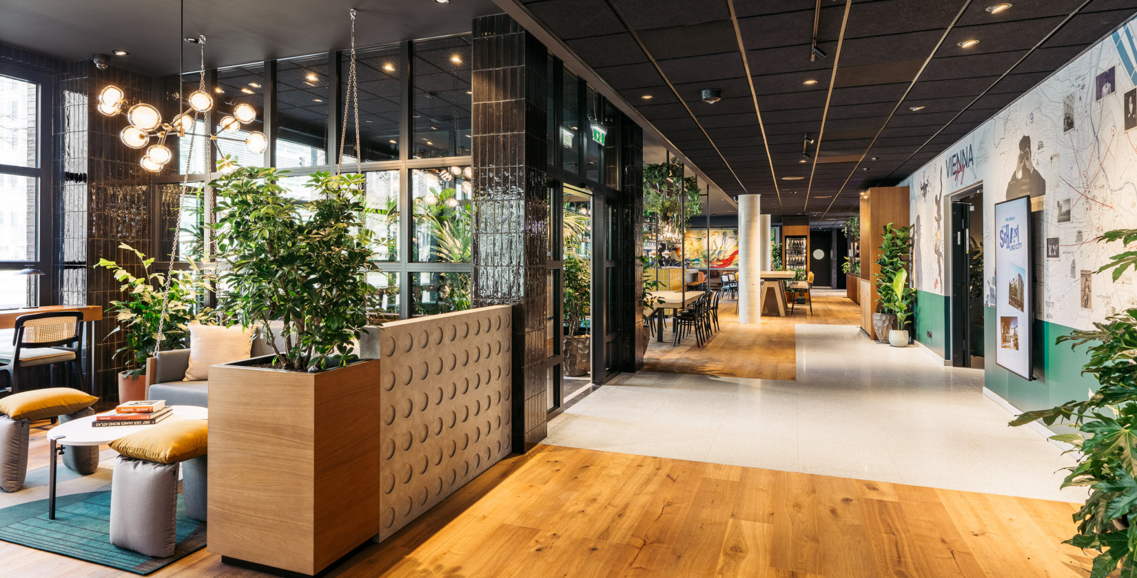 Lobby und Gemeinschaftsbereich mit Holzboden, Pflanzen und dekorativer Einrichtung