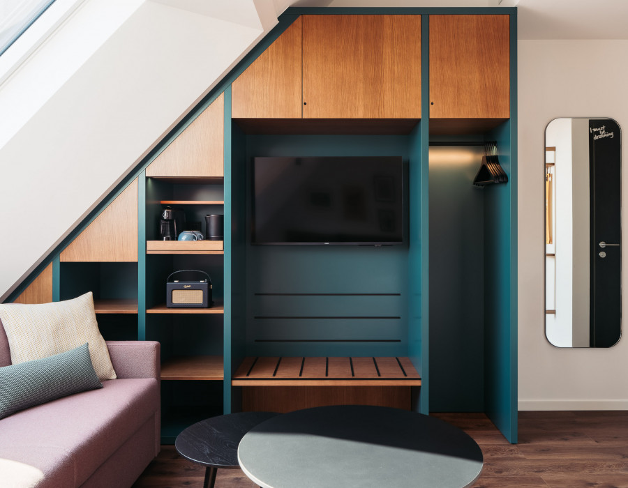 Open wardrobe and a TV next to a sofa in a family room in Vienna