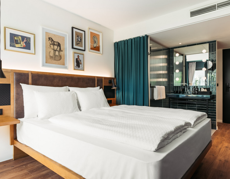 Double bed next to the open bathroom in a Smart Rooftop Room at Hotel Schani UNO City