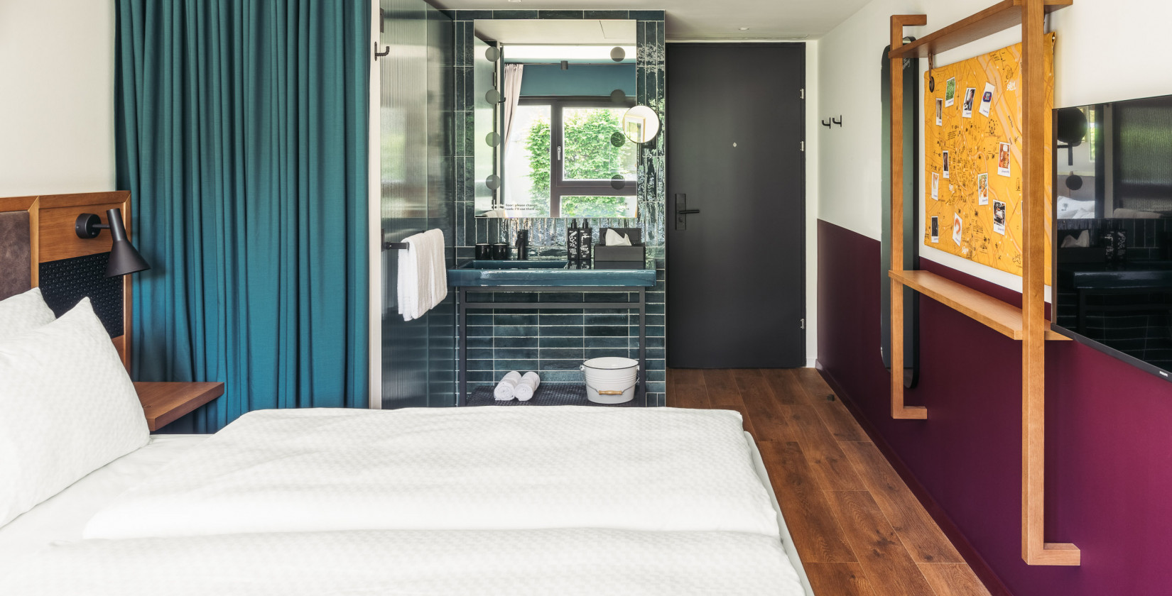 Doppelbett und offenes Badezimmer in einem Smart Street Zimmer im Hotel Schani UNO City