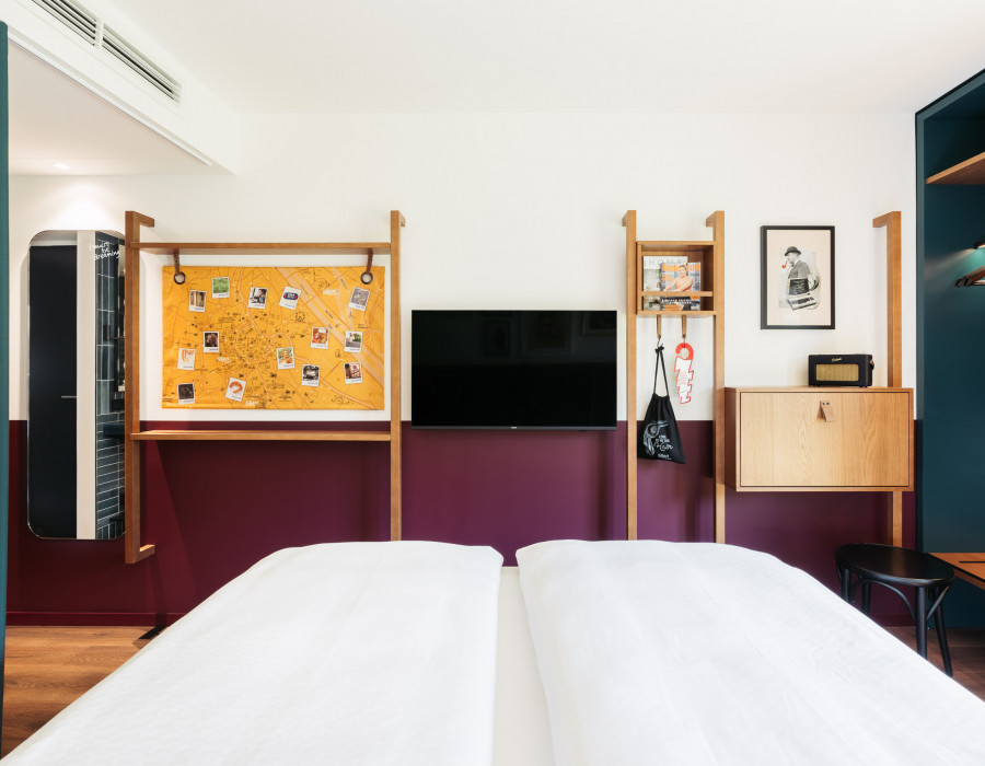 View from the bed to the TV, a desk and a city map of Vienna on the opposite wall