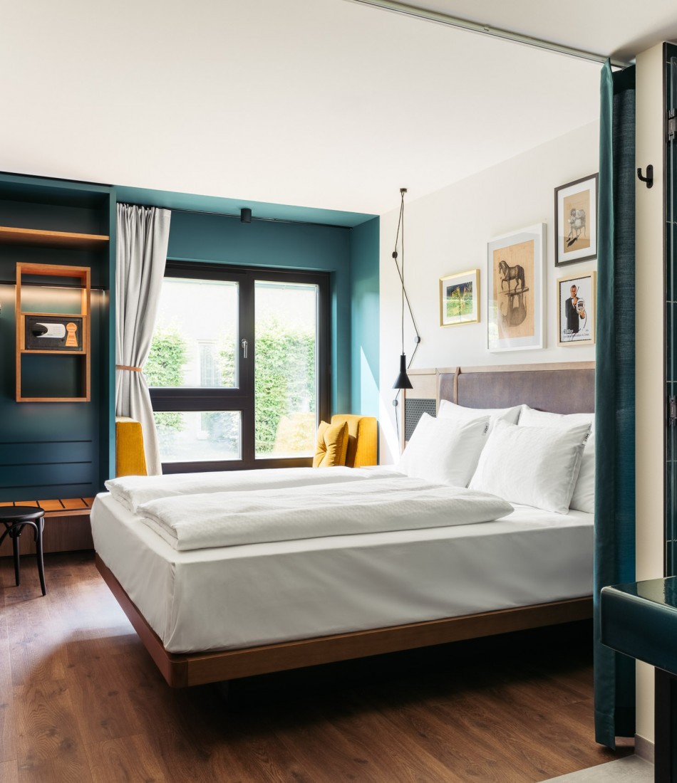 Doppelbett, Sitzbank und offener Schrank im Hotel Schani UNO City
