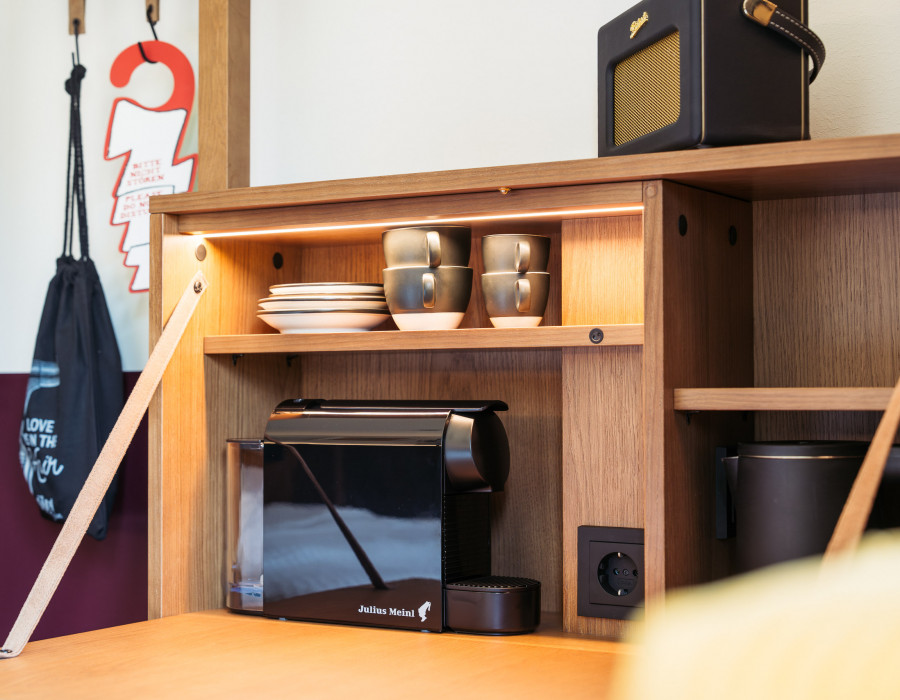 Kaffeemaschine, Radio und Wasserkocher auf einem ausklappbaren Schreibtisch