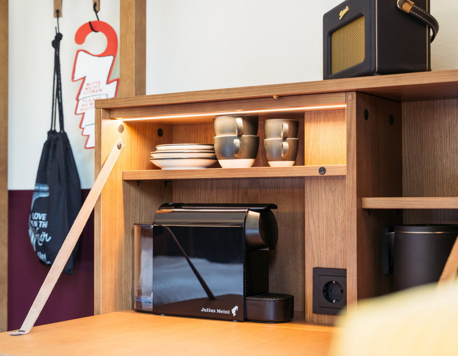 Radio, Kaffeemaschine und Wasserkocher auf einem ausklappbaren Schreibtisch