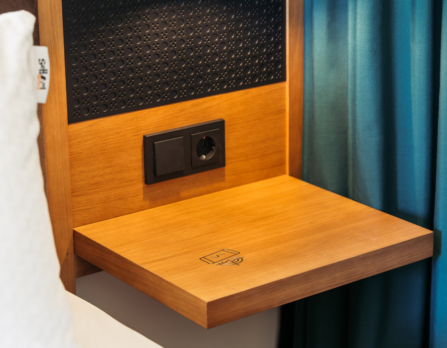 Kabellose Handy-Ladestation auf einem Nachttisch aus Holz 