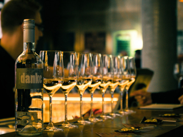 Eight filled white wine glasses at the bar at Hotel Schani Wien