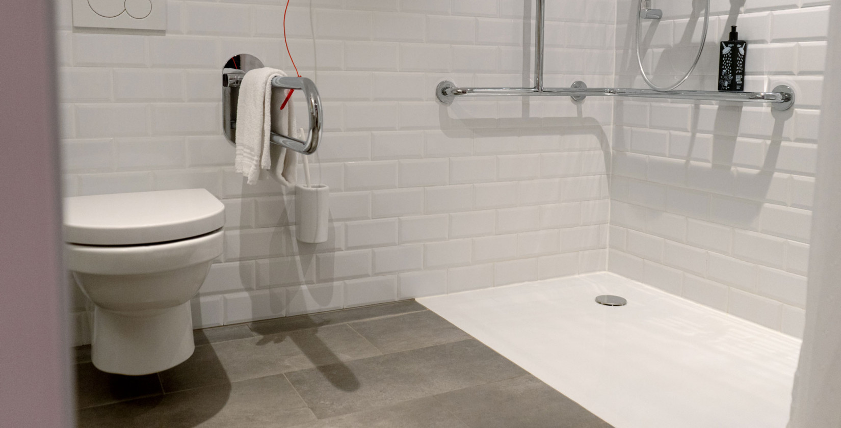 Barrier-free bathroom with handles in the shower and by the toilet