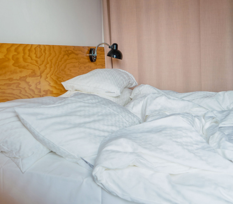 Bett mit weißer Bettwäsche im Hotel Schani Wien