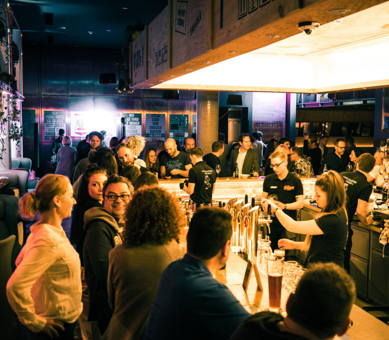 Viele Menschen an der Bar in der Eventlocation in Wien