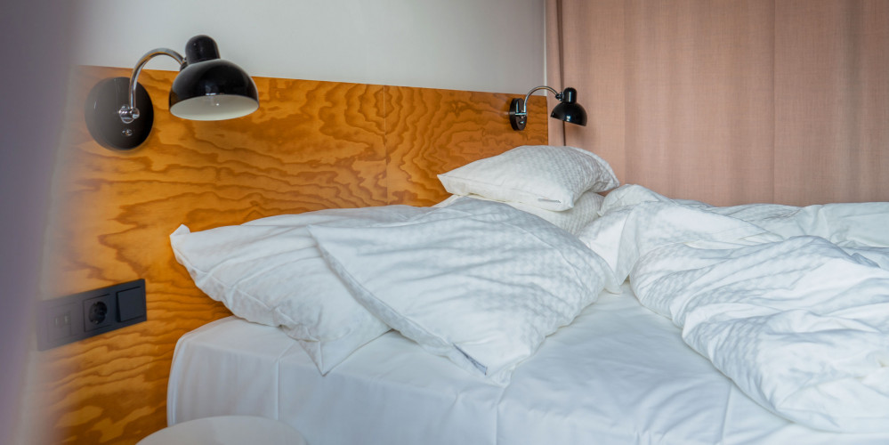 Unmade bed with Fairtrade bedding at Hotel Schani Wien