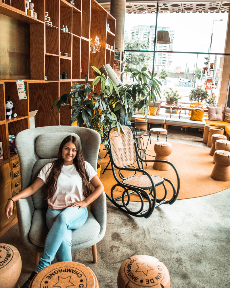 A woman sitting in a comfortable chair in the lobby at Hotel Schani Wien