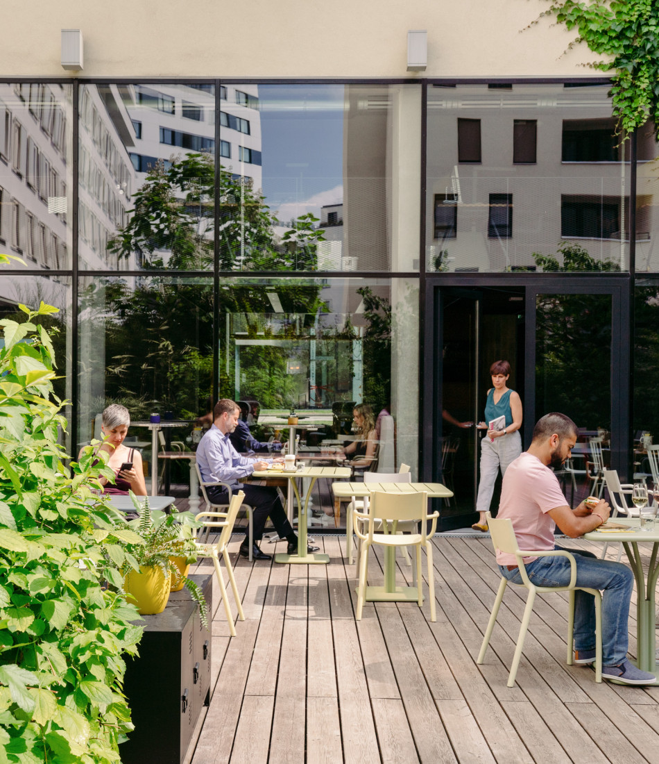 Gäste sitzen in Schani's Garten, der Grünoase mitten in der Stadt 