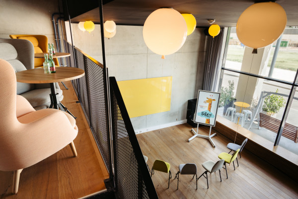 View from a maisonette down to a canvas wine in front of which are colorful chairs 