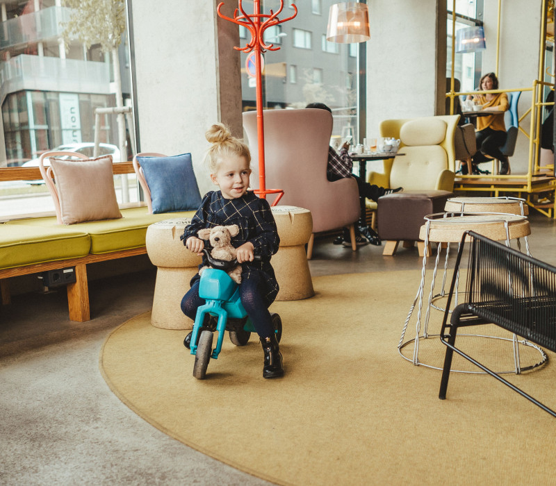 Little girl on tricycle in lobby at hotel Schani Wien