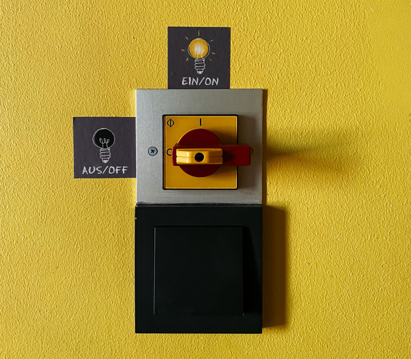 Labelled light switch on a yellow wall