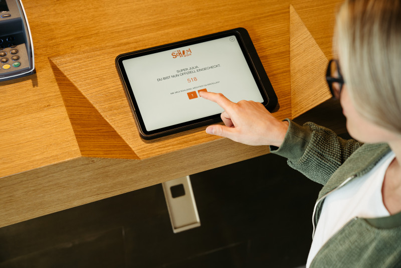 Frau am Tablet beim Self Check-in im Hotel Schani Wien