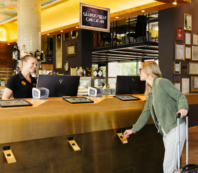 Woman at self check-in in the lobby at Hotel Schani Wien 