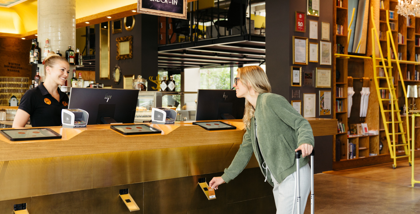 Frau beim Self Check-in in der Lobby im Hotel Schani Wien