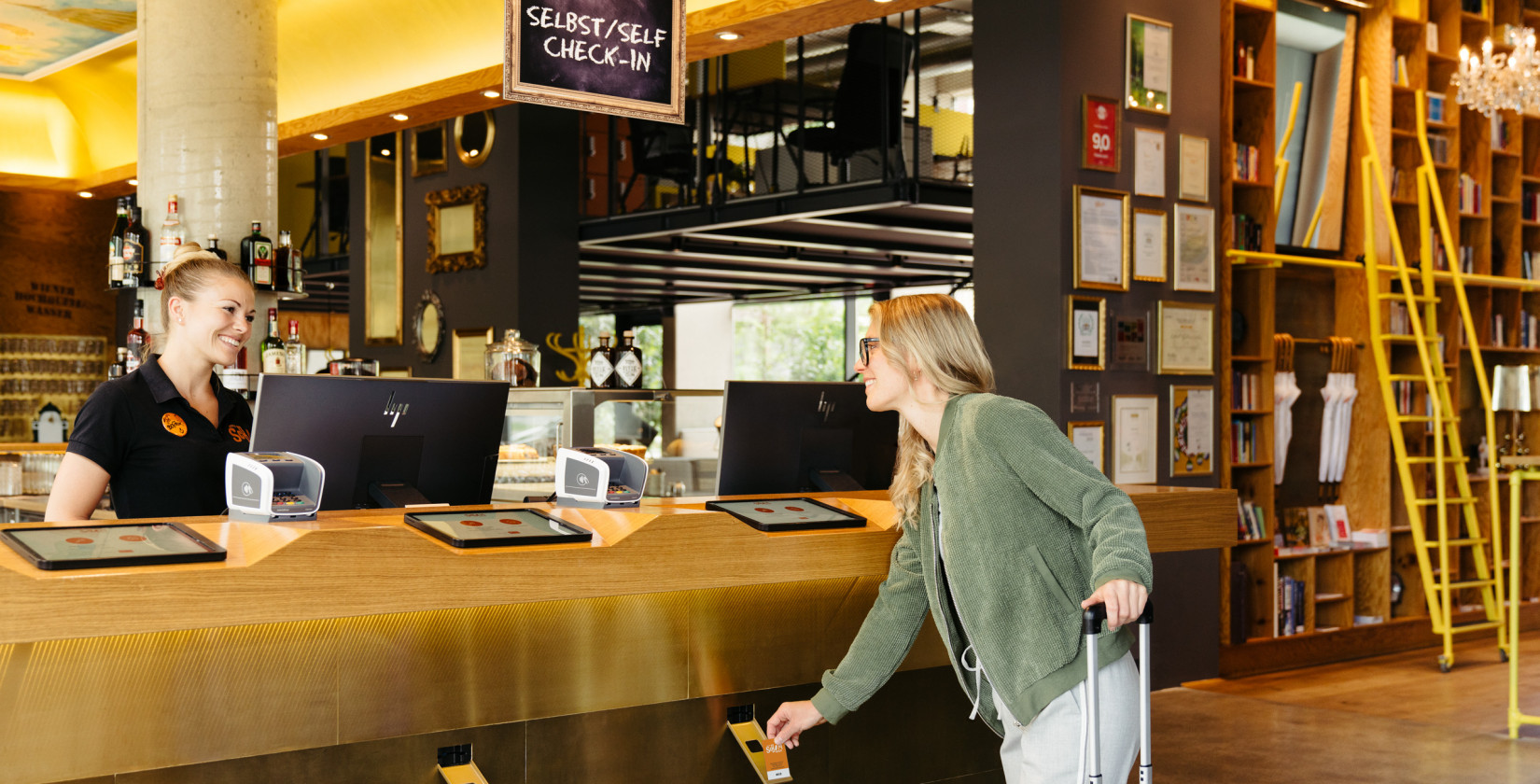 Woman at self check-in in the lobby at Hotel Schani Wien