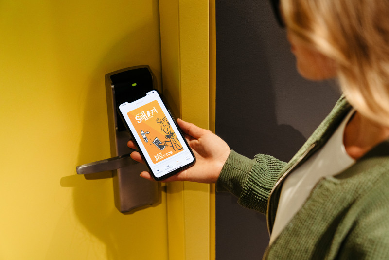 Woman opens her room door with the digital room key