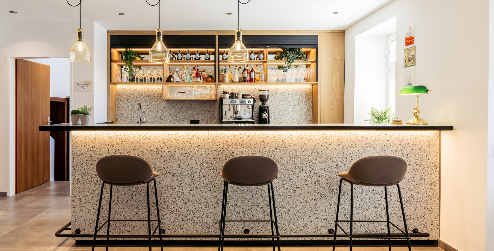 Bar area with three chairs in front of the bar in the Bio-Hotel Schani Wienblick