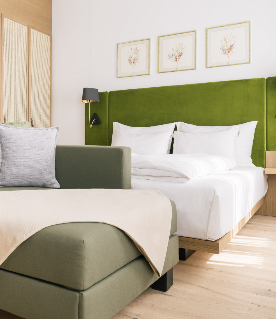 Double bed and sidesleeper sofa in a Smart Double Room at Bio-Hotel Schani Wienblick