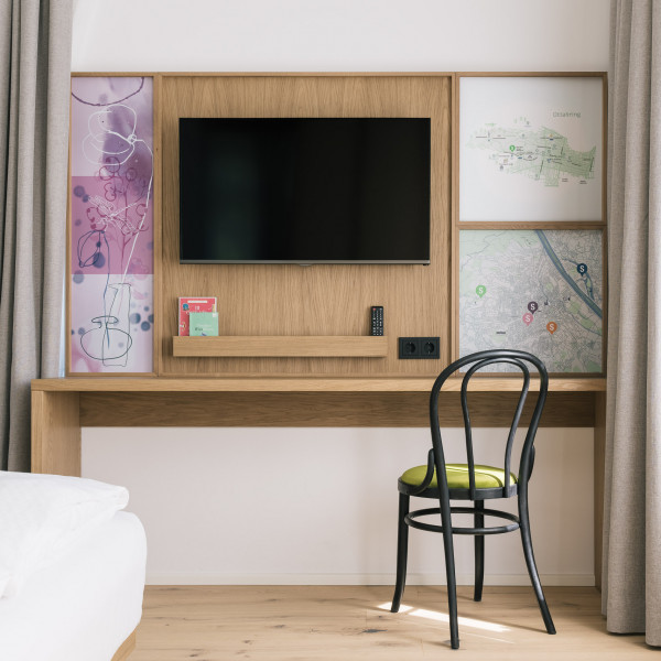 Desk with chair and a TV on the wall in the Smart Double room