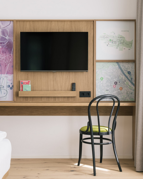 Desk with chair and a TV on the wall in the Smart Double room in the eco hotel in vienna