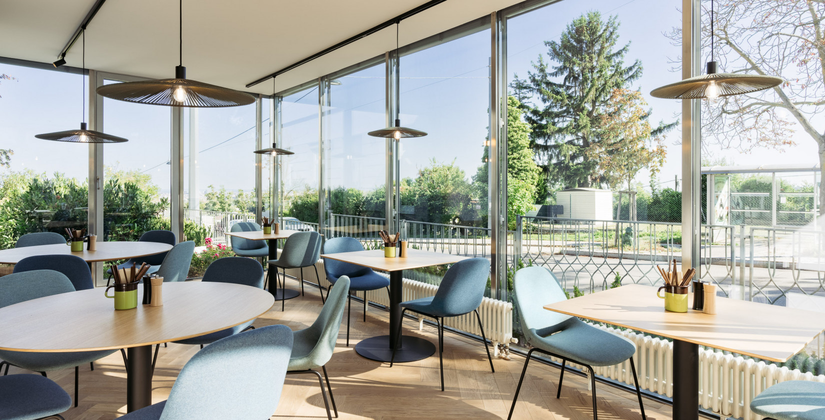 Wintergarten mit großer Fensterfront und Blick über die Stadt im Bio-Hotel Schani Wienblick