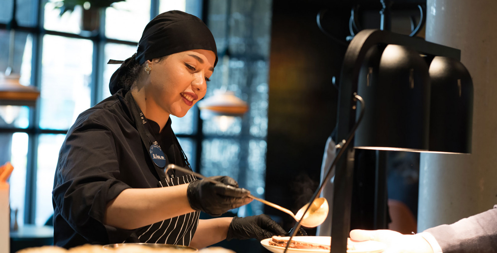 Eine Köchin beim Teller anrichten