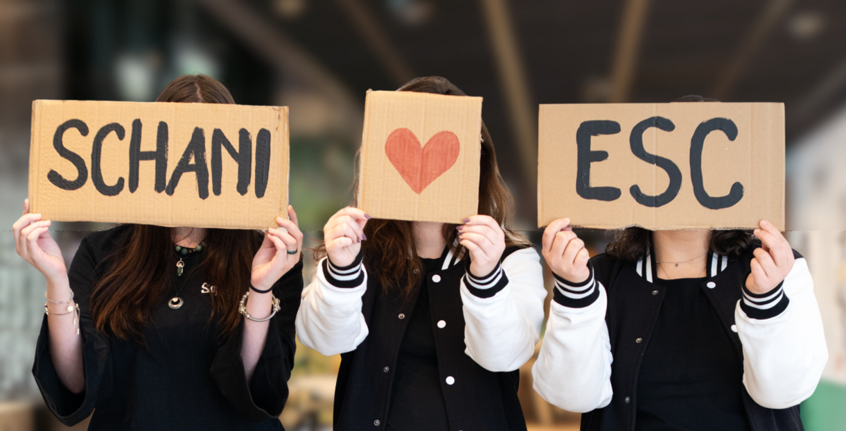Drei Personen halten Schilder auf denen steht Schani loves ESC