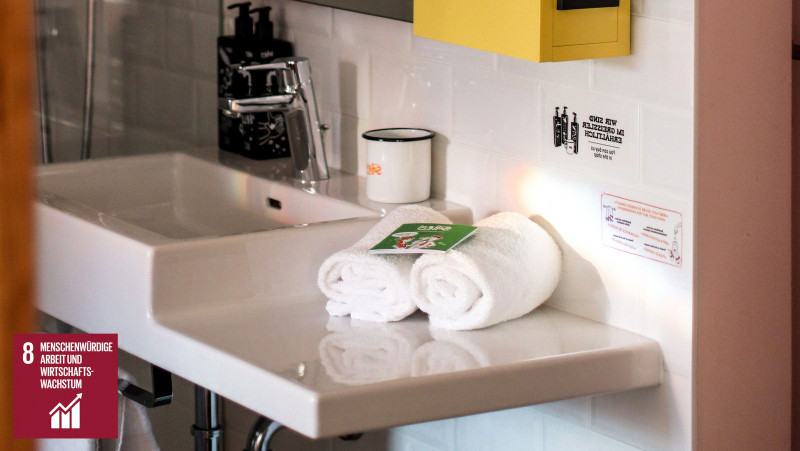 Handtücher aus Bio-Baumwolle neben einem Waschbecken im Hotel Schani Wien
