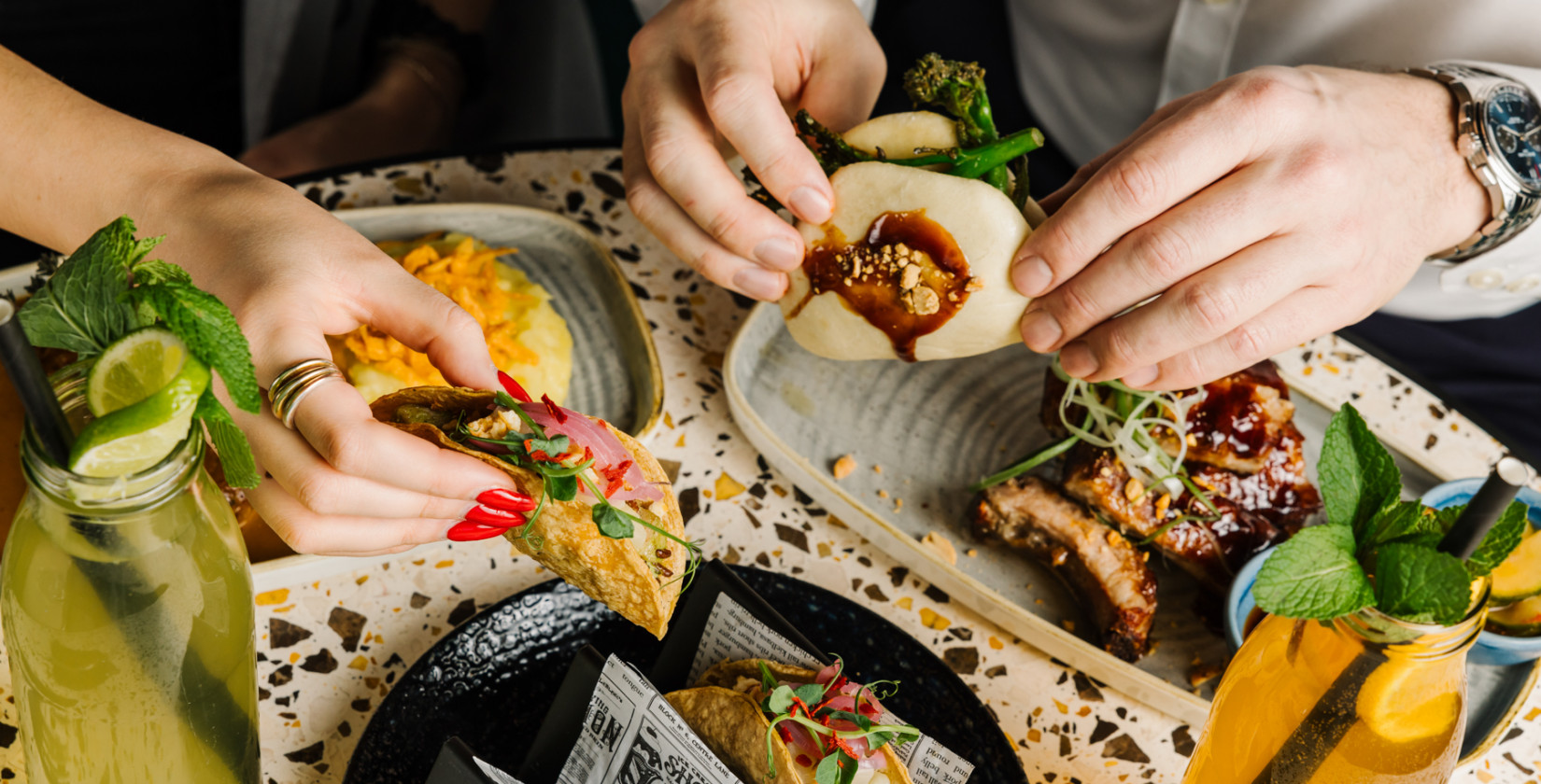Zwei Personen teilen sich die Sharing Plates in der Seven Botanicals Bar & Kitchen