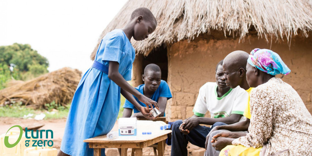 Menschen in Uganda wird das UV Messgerät für sauberes Trinkwasser erklärt 