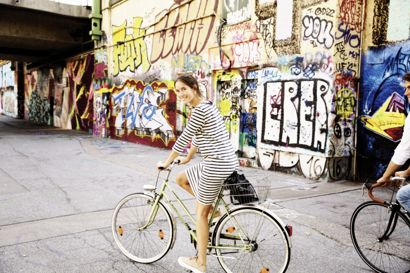 Woman cycling on the banks of a canal in Vienna